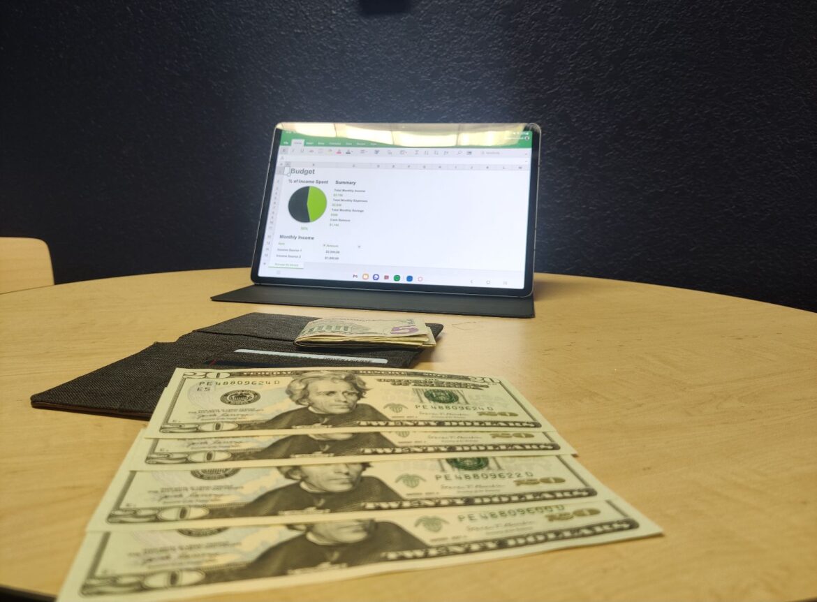 laptop displaying chart with money in front of it